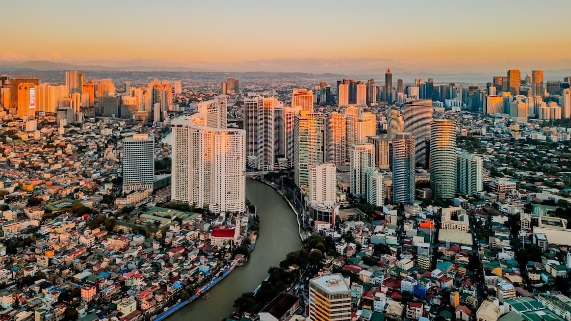 Aerial view of Manila skyline at sunset showing urban communities and businesses